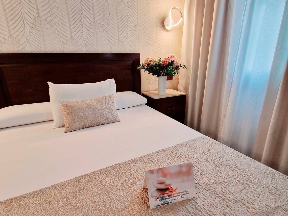 una habitación de hotel con una cama y una tarjeta de bienvenida