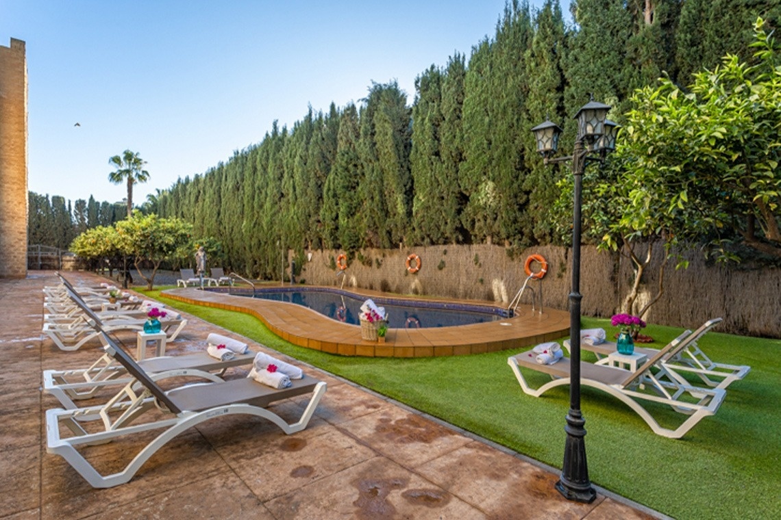 a swimming pool is surrounded by chairs and trees