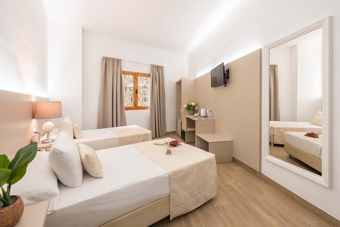 a hotel room with two beds and a large mirror