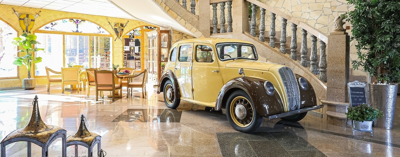 a yellow car is parked under a staircase in a lobby