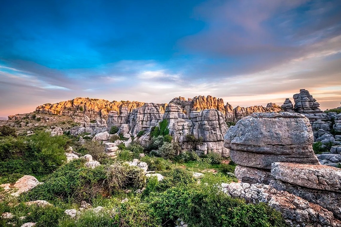 montañas cubiertas de rocas y árboles con un cielo nublado en el fondo