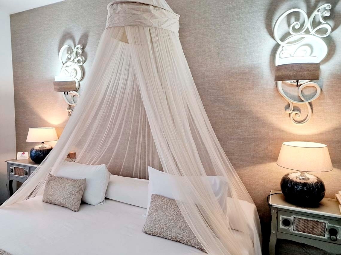 a bed with a canopy and two lamps on it