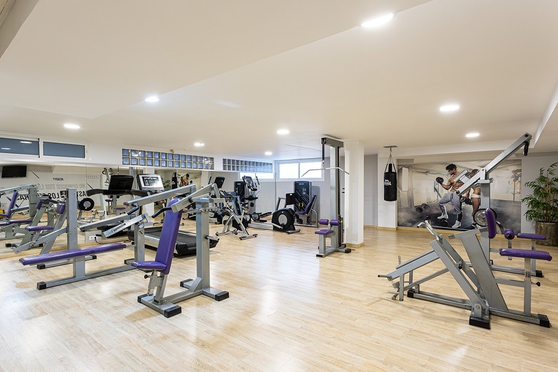 un gimnasio lleno de aparatos y una bolsa de boxeo