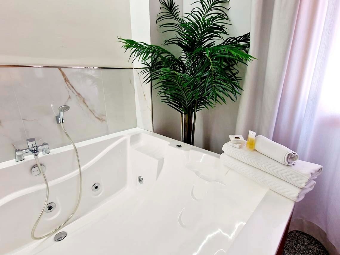 a white bathtub with a palm tree in the background