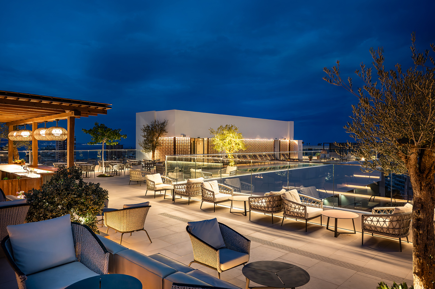 una terraza con muebles y una piscina al fondo