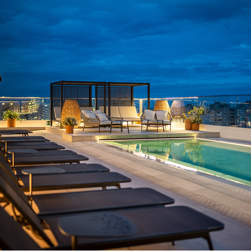 una piscina en la azotea de un edificio al atardecer