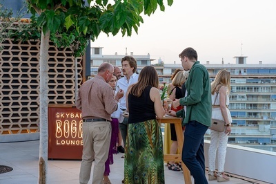 un grupo de hombres y mujeres se paran frente a un cartel que dice skybar boge lounge - 