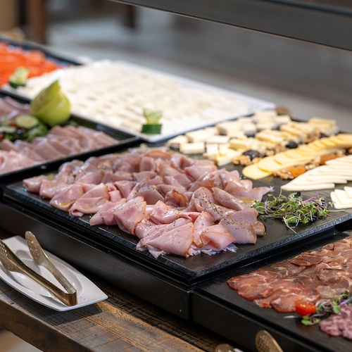 a buffet table with a variety of meats and cheeses