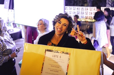 a woman holding a sign that says lote 5 - 