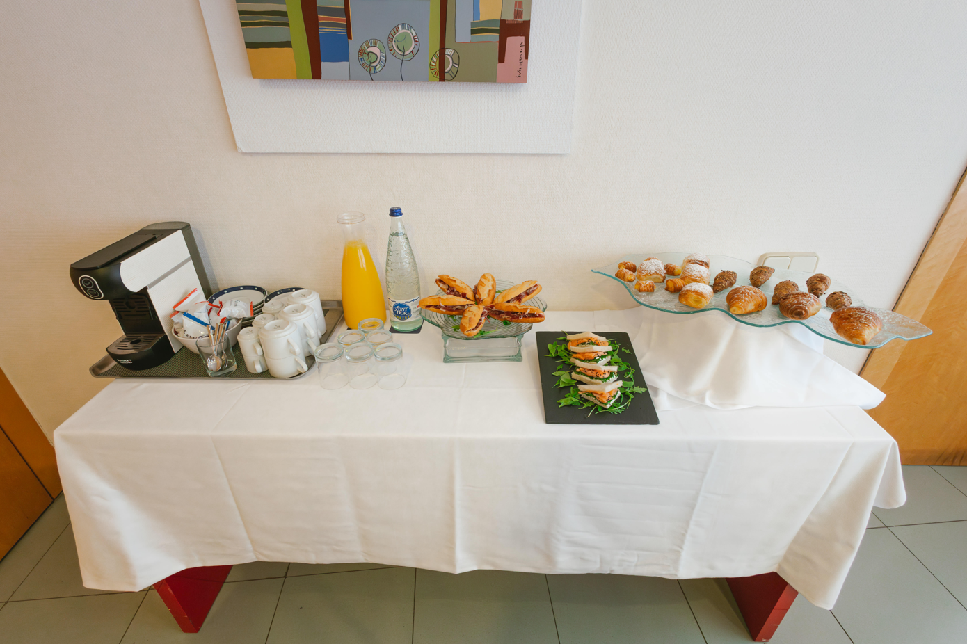 una sala de conferencias con mesas y sillas y una pantalla