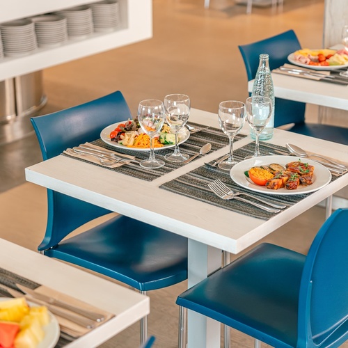 a restaurant setting with plates of food and wine glasses