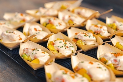 a tray of wooden boats filled with food with spoons - 