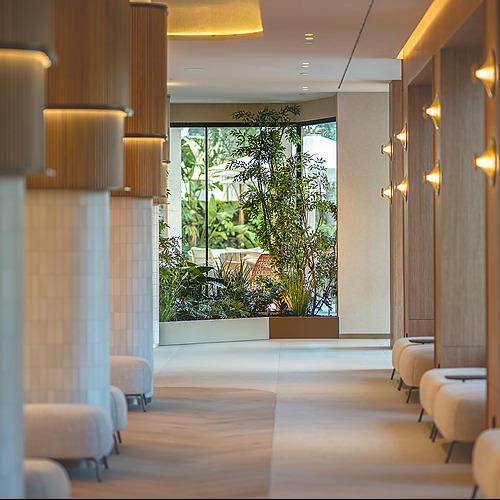 Pasillo de hotel moderno con plantas y asientos. Port Hotels: Corporativa