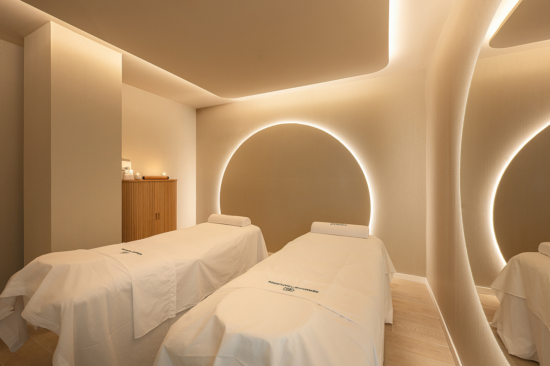 Habitación de spa con dos camillas, iluminación ambiental y decoración circular. Bienestar Port Benidorm Hotel & Spa | Port Hotels | Web Oficial