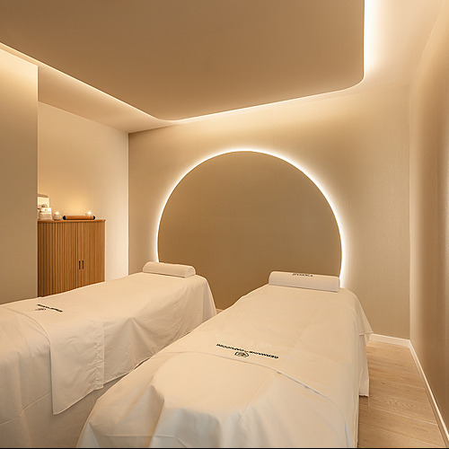 Dos camillas para tratamientos en spa de hotel, con iluminación ambiente y detalles elegantes. Port Hotels: Corporativa