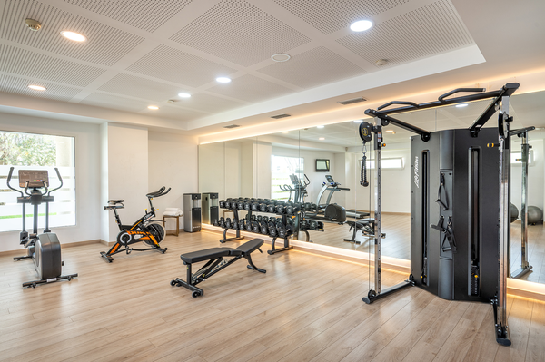 un gimnasio con una bicicleta está rodeado de espejos y pesas