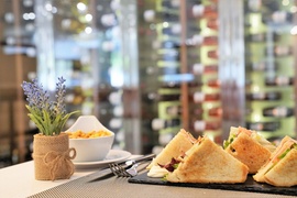 un plato de sándwiches y un tazón de maíz están sobre una mesa