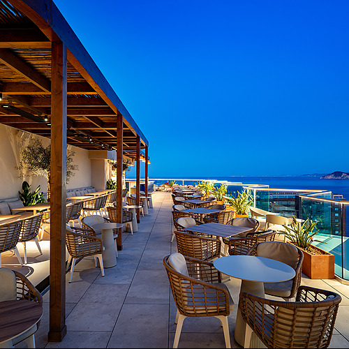 Terraza de hotel con vista al mar Port Hotels: Corporativa y mesas al aire libre.