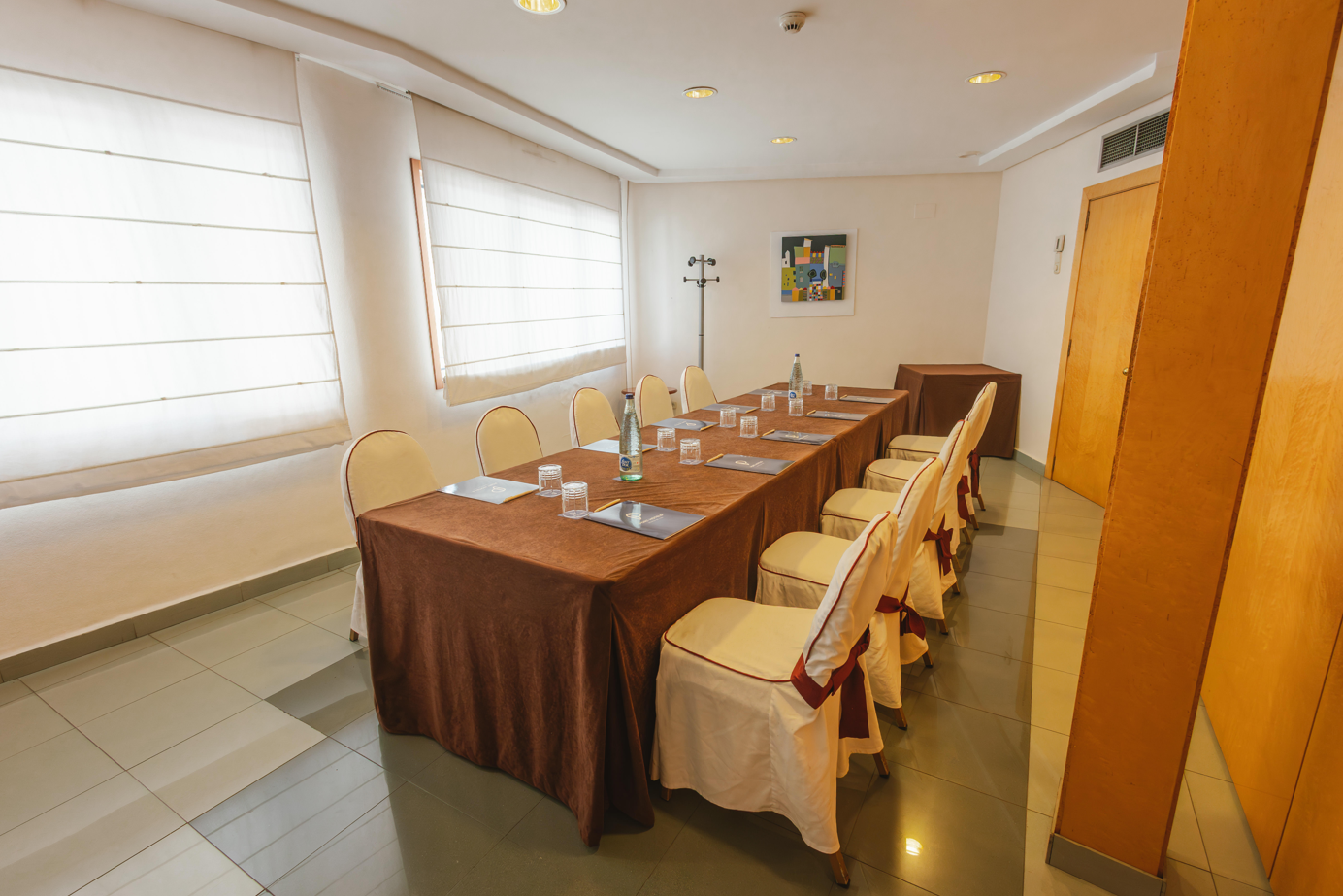 una sala de conferencias con mesas y sillas y una pantalla