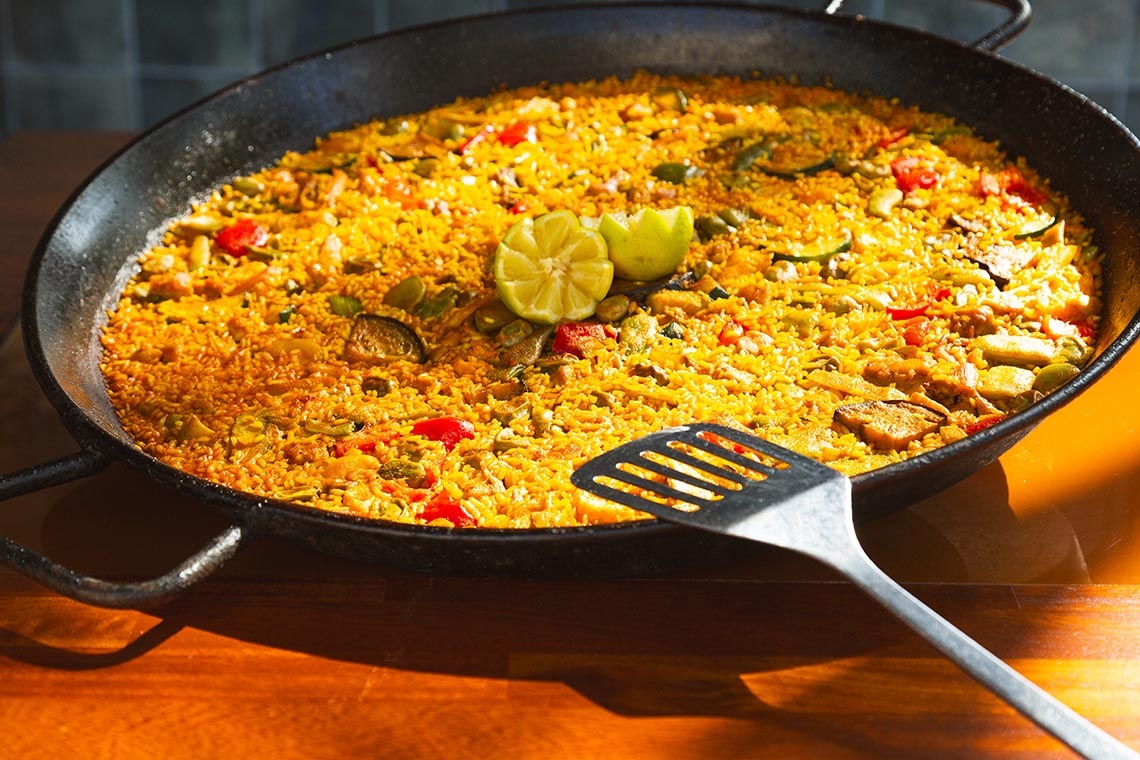 Paella vibrante servida em paellera, perfeita para eventos corporativos do Port Hotels.