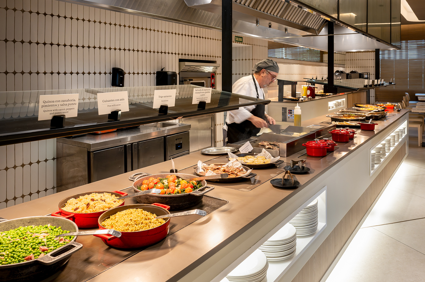un chef prepara comida en una cocina con un montón de platos de comida