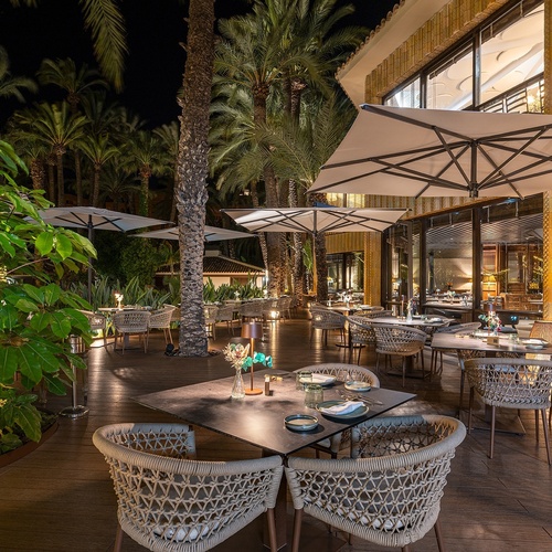 a restaurant with tables and chairs and umbrellas at night