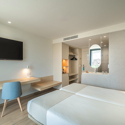 una habitación de hotel con dos camas y una televisión