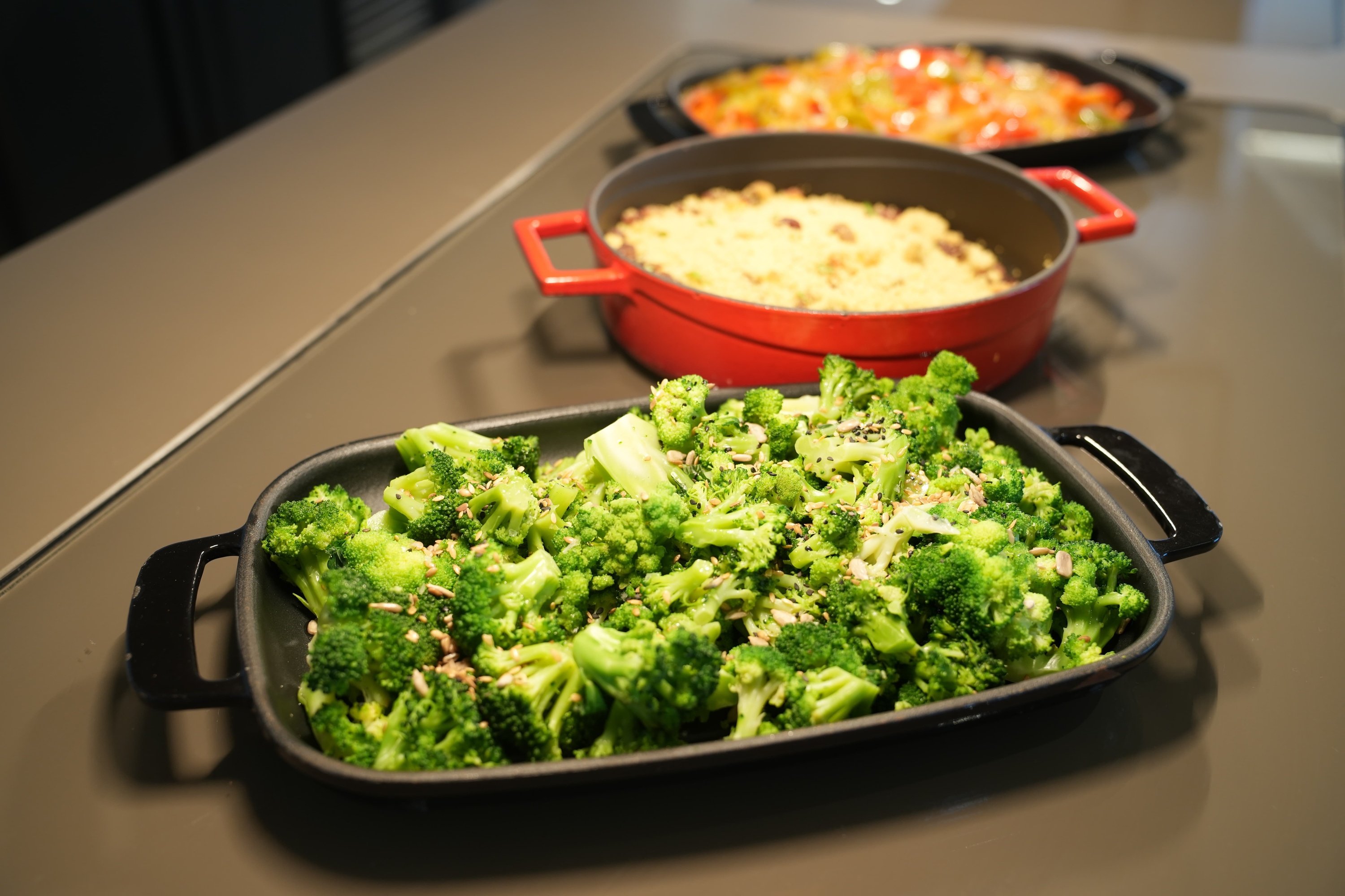 a tray of broccoli sits on a table next to a pot of food