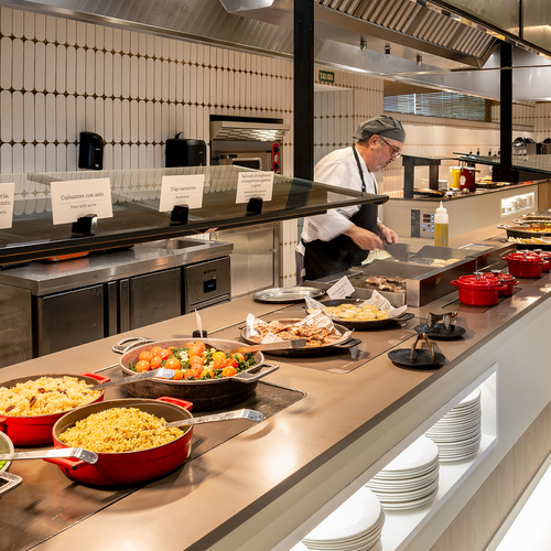 un chef prepara comida en una cocina con un montón de platos de comida