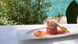 un plato de comida está sobre una mesa frente a una piscina