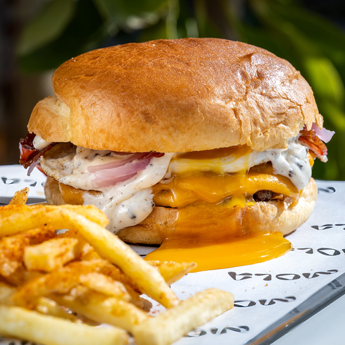 un primer plano de una hamburguesa y papas fritas en una mesa