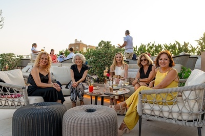 a group of women sit at a table with drinks - 