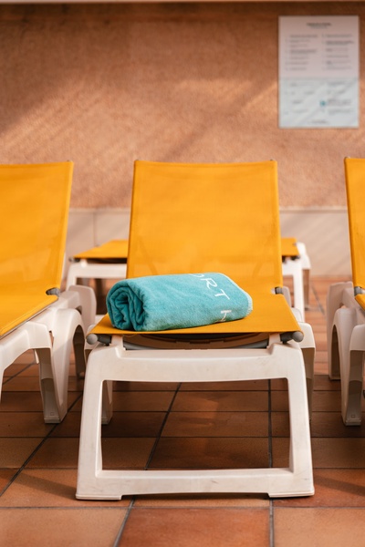 una piscina cubierta con sillas amarillas y mesas