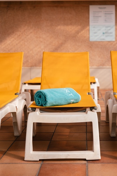 una piscina cubierta con sillas amarillas y mesas