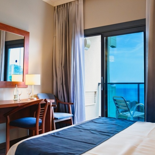 Port Hotels: Corporativa king bed with ocean view balcony.