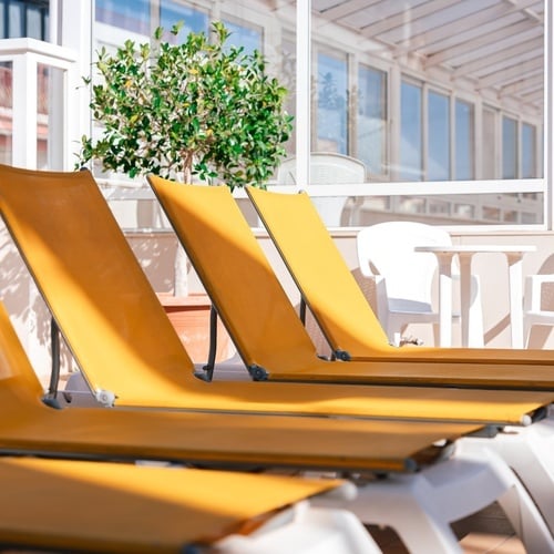 a row of yellow lounge chairs in front of a window