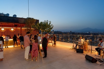 a group of people are gathered on a rooftop at night - 