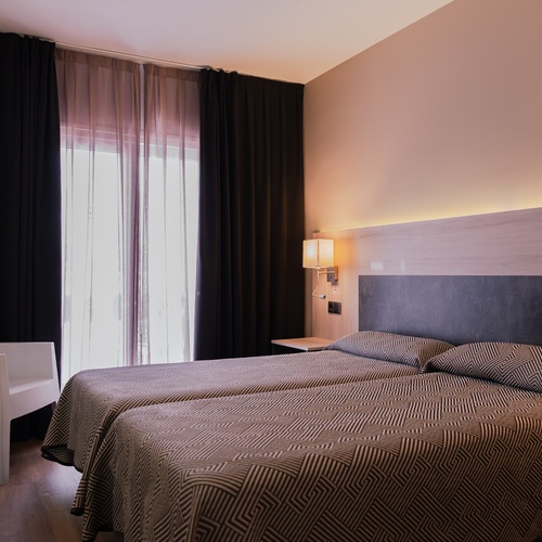 una habitación de hotel con dos camas y una ventana