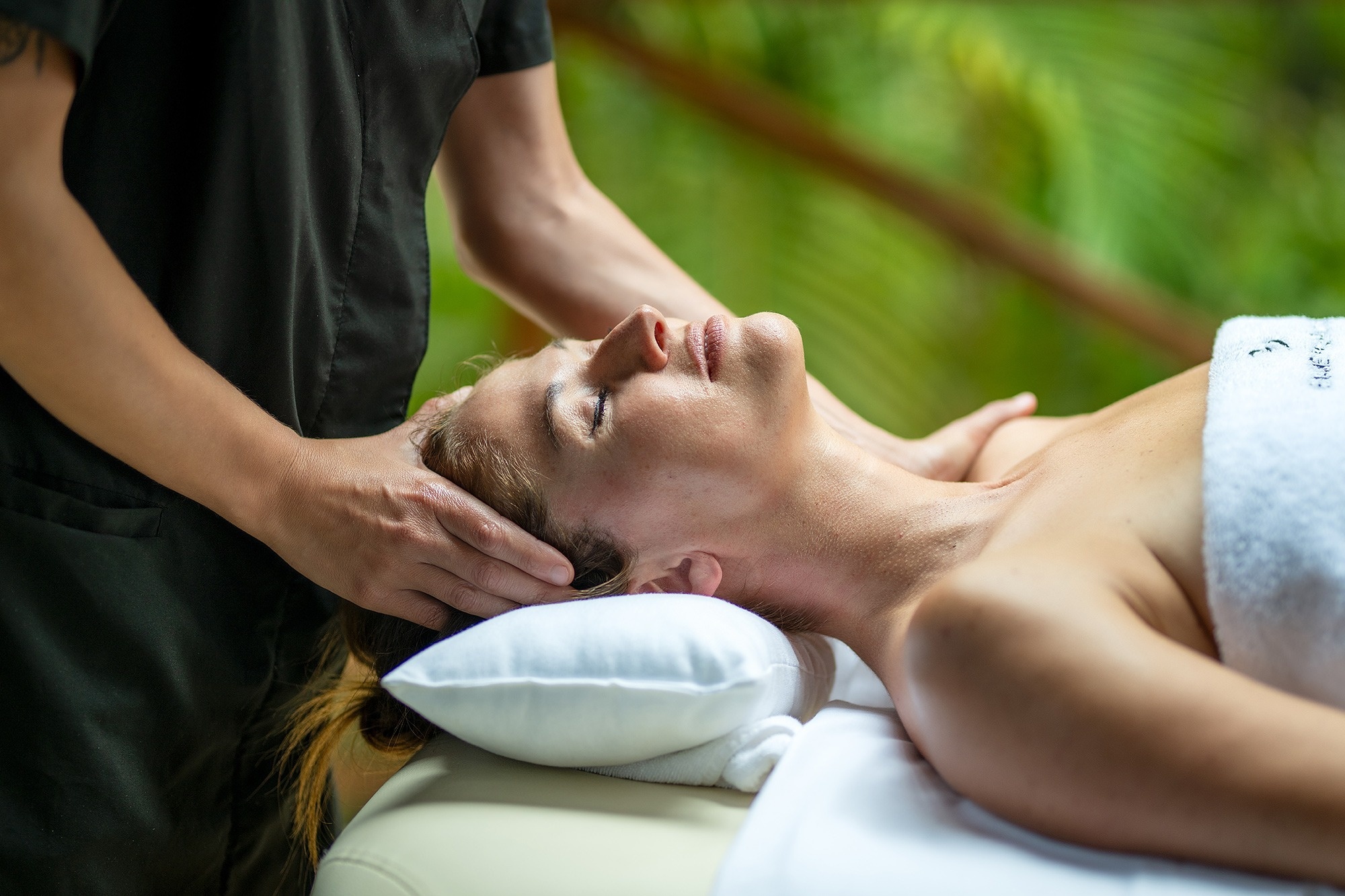 a hot tub is surrounded by lounge chairs under a wooden roof