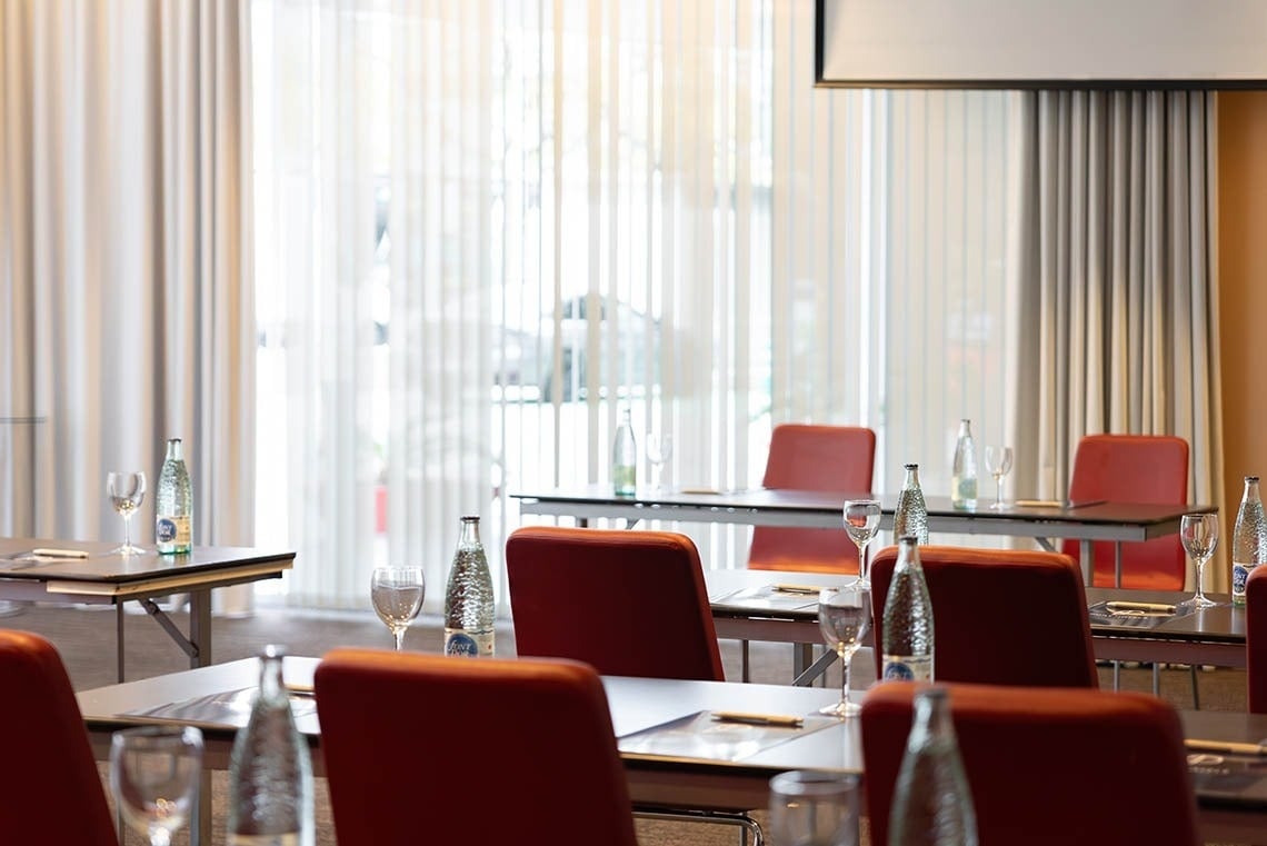 a conference room with tables and chairs and bottles of water