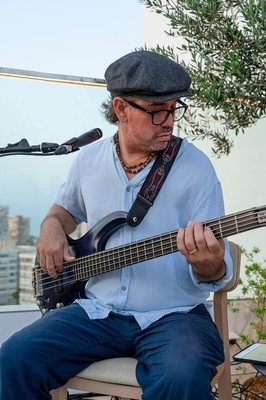 a man wearing glasses and a hat is playing a guitar - 