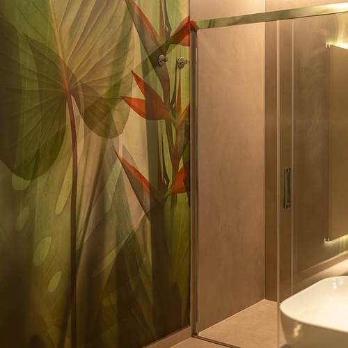 a bathroom with a painting of leaves on the wall