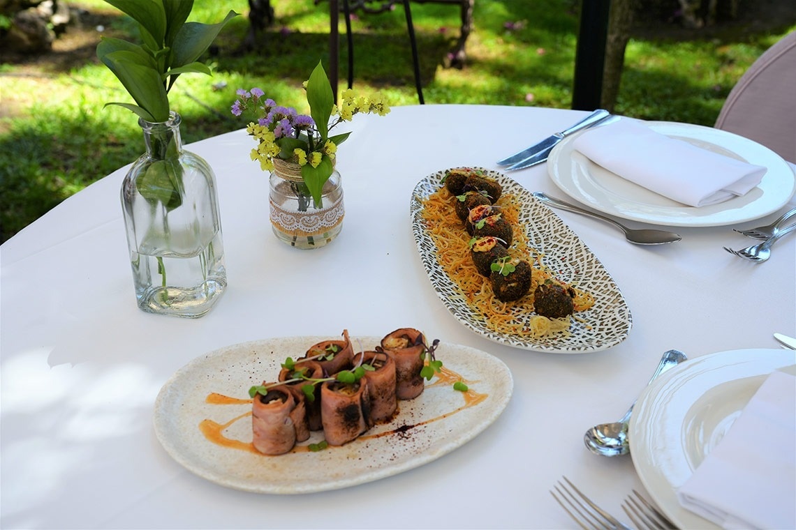 una mesa con platos de comida y un jarrón de flores