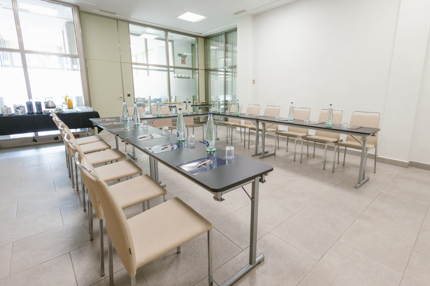 una sala de conferencias con mesas y sillas y botellas de agua