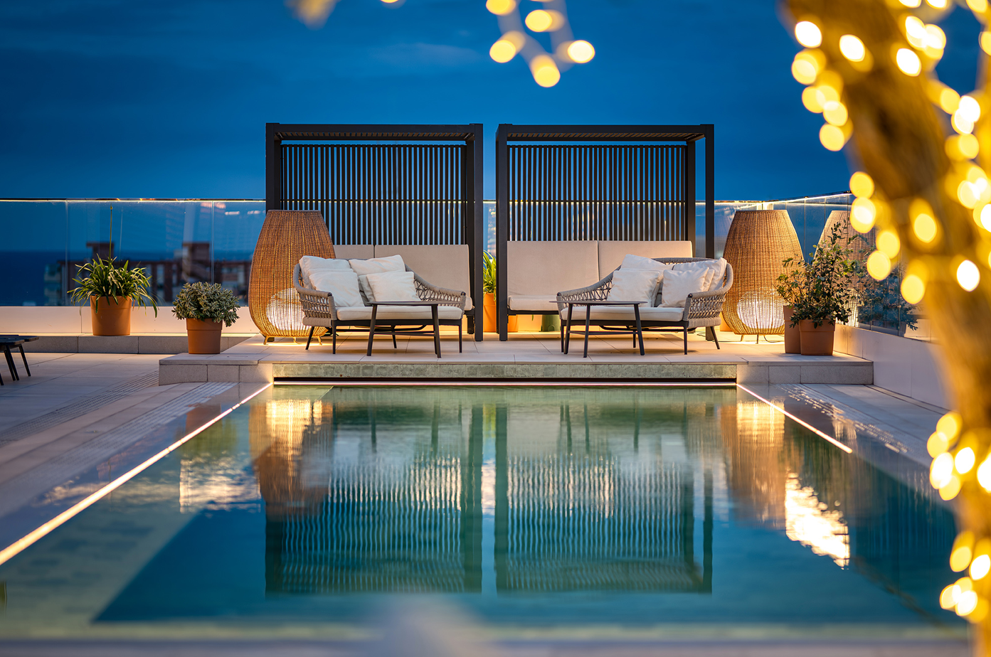 una piscina rodeada de muebles y luces de navidad