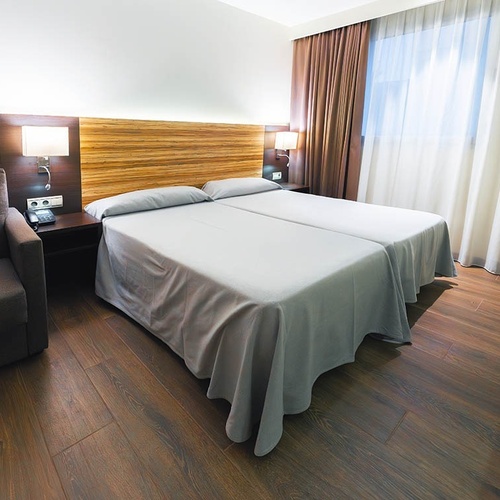 una habitación de hotel con dos camas y una silla