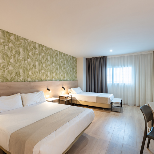 una habitación de hotel con dos camas y una televisión