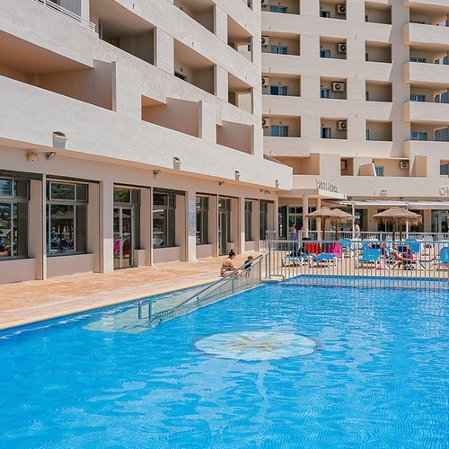 a large swimming pool with a hotel in the background