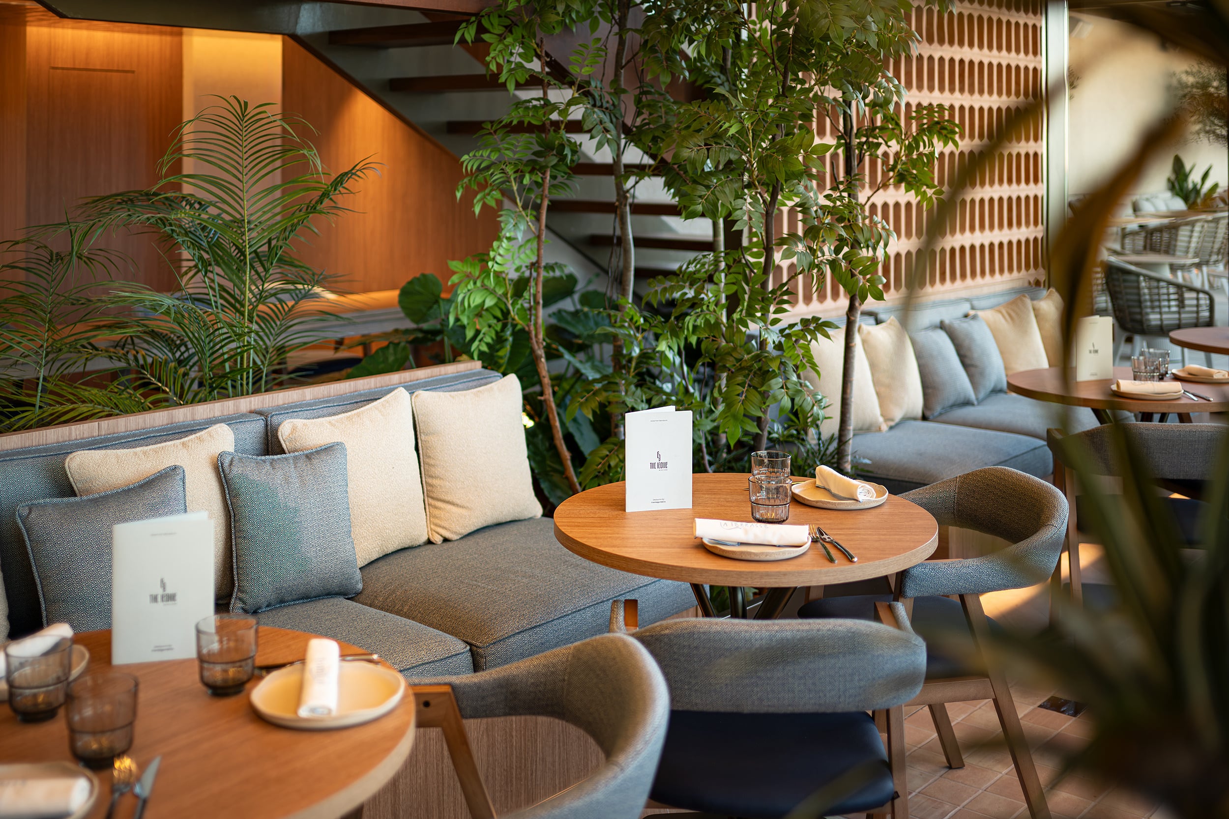 Sofá moderno y mesas en restaurante de hotel, diseño elegante Port Hotels: Corporativa