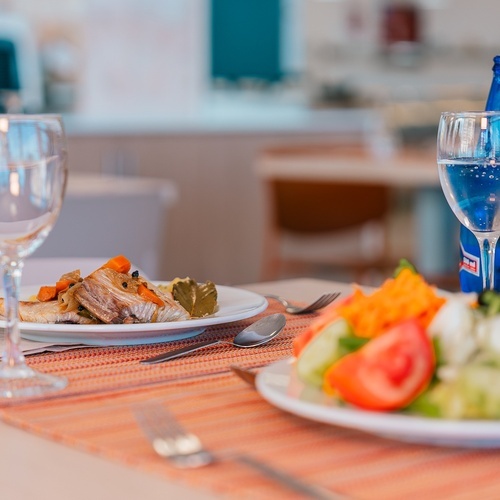 una mesa con un plato de comida y una botella de agua